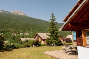 a porch of a house with a picnic table and a tree at Chalet premium -Accès pied de piste en navette in Saint-Chaffrey