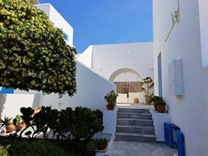 - un bâtiment blanc avec des escaliers et un arbre dans l'établissement Villa Sophie, à Náoussa
