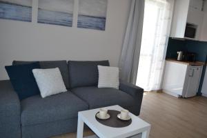 a living room with a couch and a table at Apartament Justynka in Kąty Rybackie
