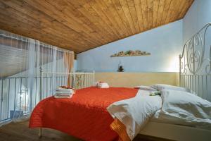 una camera con letto rosso e soffitto in legno di Ambra di mare a SantʼAgata di Militello