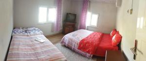 a bedroom with two beds and a tv in it at Arzu pansiyon in Aybastı