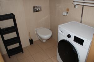 eine Waschmaschine im Bad mit WC in der Unterkunft Apartament za wydmą Sosnowa 13 in Mielno