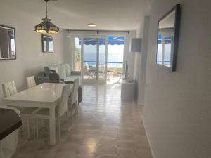 a dining room and living room with a table and chairs at Cristina's Cancajos Beach in Los Cancajos