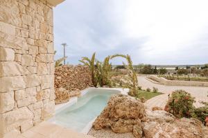 a swimming pool in a stone building with a stone wall at Agriresort Murciano in Otranto
