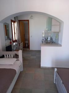 een keuken en een woonkamer met een bed en een wastafel bij Pension Patelo in Pitsidia