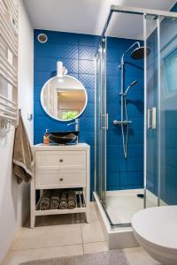 La salle de bains est pourvue d'un lavabo et d'une douche. dans l'établissement Domek MorzeLasu Ostrowo Jastrzębia Góra, à Ostrowo