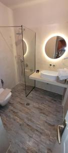 a bathroom with a sink and a toilet and a mirror at Hotel Grand Nefeli in Vasiliki