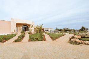 una casa con un vialetto di mattoni di fronte a un edificio di Agriresort Murciano a Otranto