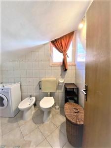 bagno con servizi igienici, lavandino e finestra di Amarante apartments a Kaštela (Castelli)