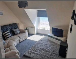 sala de estar con sofá y TV en Inviting 1-Bed Apartment in Campbeltown Loch views en Campbeltown