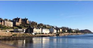 a town on the shore of a river with houses at Inviting 1-Bed Apartment in Campbeltown Loch views in Campbeltown