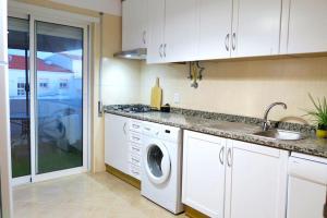 a kitchen with a washing machine and a sink at Albufeira Central Apartment, 10 mins walk to beach in Albufeira