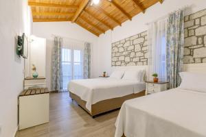 a bedroom with two beds and a stone wall at Alacati Fora Bella in Alacati +74 photos