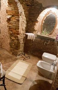 uma casa de banho em pedra com um lavatório e um WC em I CATARI ...nel cuore di Monforte d'Alba em Monforte dʼAlba