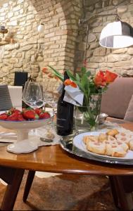 uma mesa com um prato de comida e uma taça de fruta em I CATARI ...nel cuore di Monforte d'Alba em Monforte dʼAlba