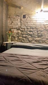 um quarto com uma cama e uma parede de pedra em I CATARI ...nel cuore di Monforte d'Alba em Monforte dʼAlba