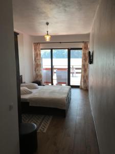 a bedroom with a bed and a large window at Complex Lacustru Clisura Dunarii in Eşelniţa