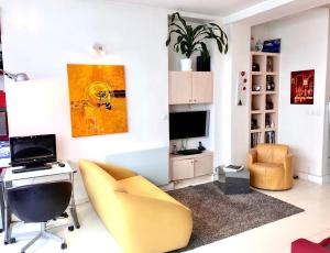 ein Wohnzimmer mit einem Schreibtisch und einem gelben Stuhl in der Unterkunft Modern Design Loft Apartment, Steps to Notre Dame in Paris