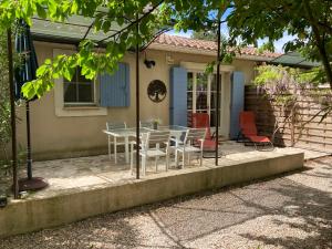 une table et des chaises devant une maison dans l'établissement Le Mas Mérindol Gîte Cerise, à Loriol-du-Comtat