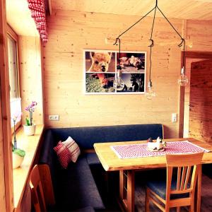 a dining room with a table and a picture of a dog at Alpakaglück in Mühlbach