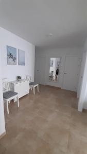 a white room with a bench and a table at Apartamento Conil La Fina in Conil de la Frontera