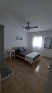 a bedroom with a bed and a ceiling fan at Apartamento Conil La Fina in Conil de la Frontera