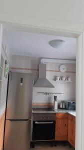 a kitchen with a stainless steel refrigerator and a stove at Apartamento Conil La Fina in Conil de la Frontera