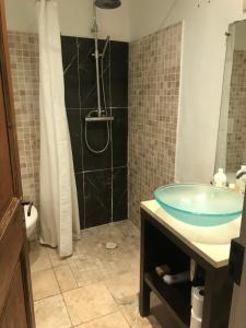 ein Badezimmer mit einem Glaswaschbecken und einer Dusche in der Unterkunft Appartement Plein sud in Port-Vendres