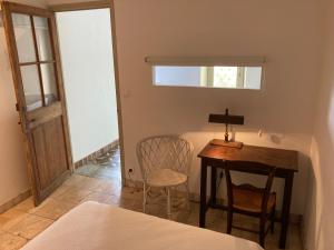 ein Schlafzimmer mit einem Tisch, einem Stuhl und einem Bett in der Unterkunft Appartement Plein sud in Port-Vendres