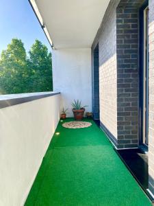 un patio vacío con suelo verde en una casa en MM Greenhouse Appartement / Tourcoing - Lille, en Tourcoing