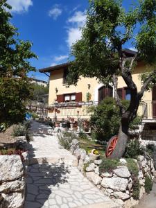 una casa con un albero e un passaggio in pietra di IL GIRASOLE a Castelvecchio Calvisio