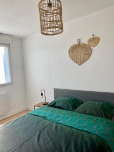 Schlafzimmer mit einem Bett und einem Kronleuchter in der Unterkunft MM Greenhouse Appartement / Tourcoing - Lille in Tourcoing