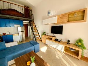 a living room with a blue couch and a tv at Apartment Blue in Sveti Stefan