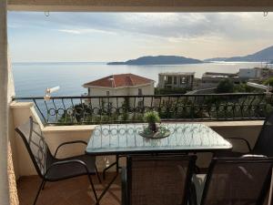 a table on a balcony with a view of the water at Apartment Blue in Sveti Stefan