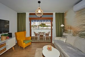 a living room with a couch and a table at Cactus Sombrerudo- bright apartment next to Yumbo in Maspalomas