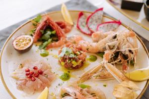 a plate of food with shrimp and other foods at Agriresort Murciano in Otranto