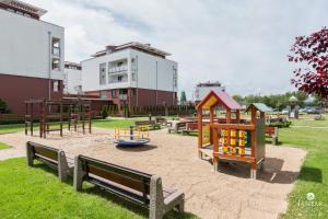 a playground with benches and play equipment in a park at Apartament Margaretville 90m in Kołobrzeg