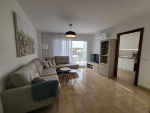 un soggiorno con divano e tavolo di Dimi Holidays Porto Cristo SLU Meerblick 4 Apartment 4 - 120 m zum Strand a Porto Cristo