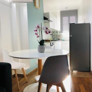 una cocina con una mesa blanca con un jarrón de flores. en Lea, en París