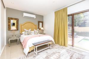 a bedroom with a bed and a large window at Fleur de Lis Guesthouse in Krugersdorp