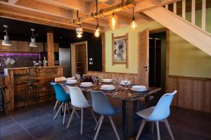 a dining room with a wooden table and blue chairs at TOUT NEUF - Chalet Paul avec sauna in La Bresse