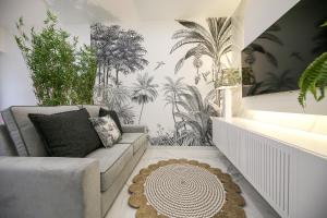 a living room with a couch and some plants at Dina Beach House Avó Mariana in Nazaré