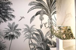 a mural of palm trees on a wall with a vase at Dina Beach House Avó Mariana in Nazaré