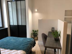 a bedroom with a table and a bed and a table and chair at DUPLEX COSY HYPER CENTRE CHOLET in Cholet