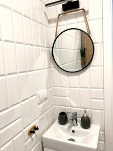 a bathroom with a sink and a mirror at Apartament Na Grobli, Przy Kładce Zwierzynieckiej in Wrocław