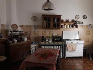 eine Küche mit einem Herd und einem Tisch darin in der Unterkunft Casa Il Girasole in Cuglieri