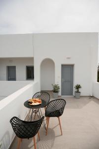 a patio with two chairs and a table with a pizza on it at Aerial Apartment in Karterados