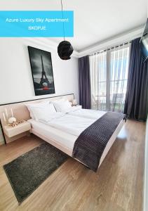 una camera con un grande letto e una grande finestra di Azure Luxury Sky Apartment a Skopje