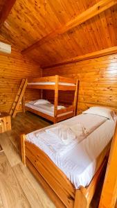 a bedroom with two bunk beds in a log cabin at La Căsuțe in Silvaşu de Jos