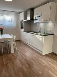 a kitchen with white cabinets and a table at FeWo Haus 4 in Lahr